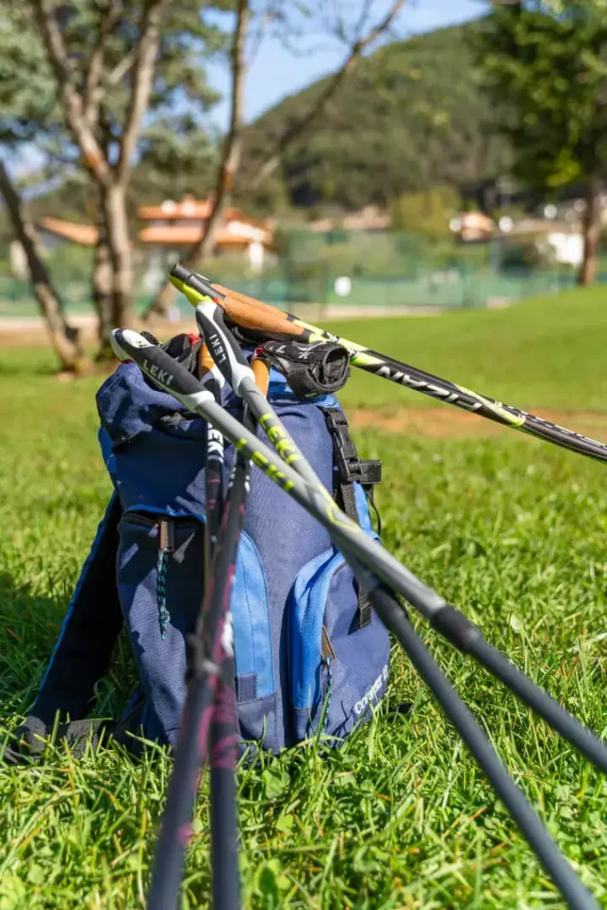 Zaino e bastoncini da trekking sull'erba.