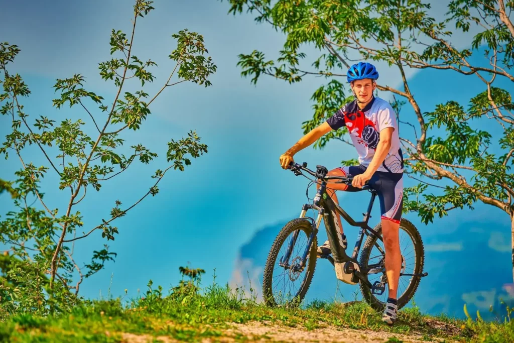 Ciclista in montagna con bicicletta e casco.