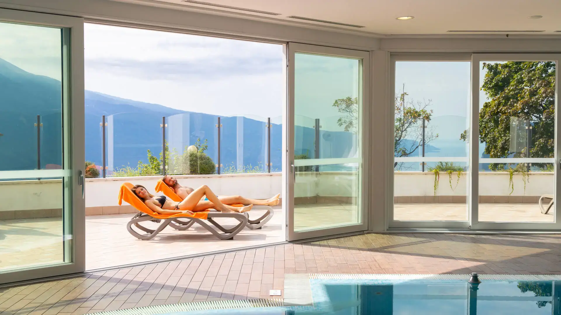 Terrazza con vista mare e persone su sdraio.