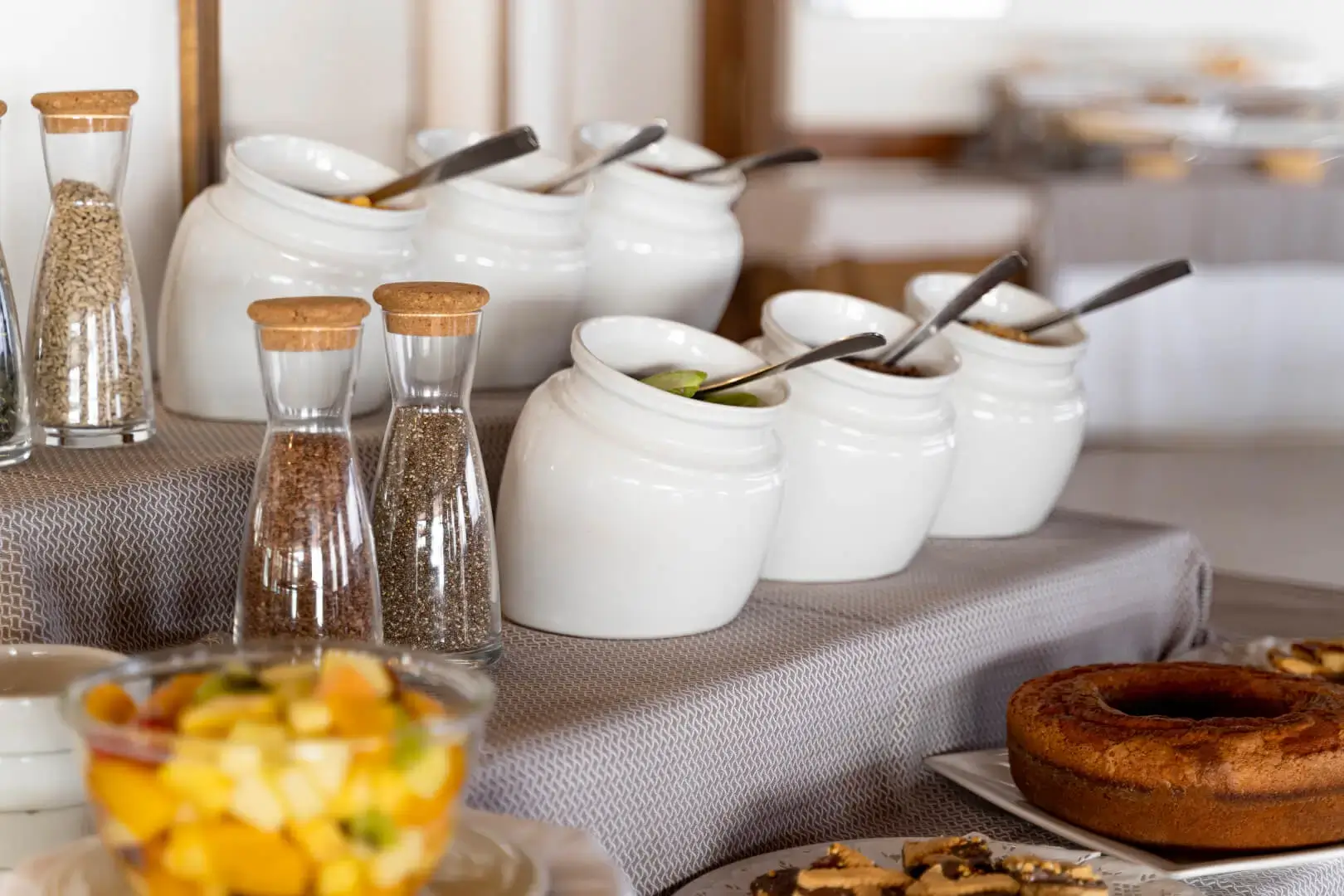Barattoli condimenti e dolci su tavolo buffet.