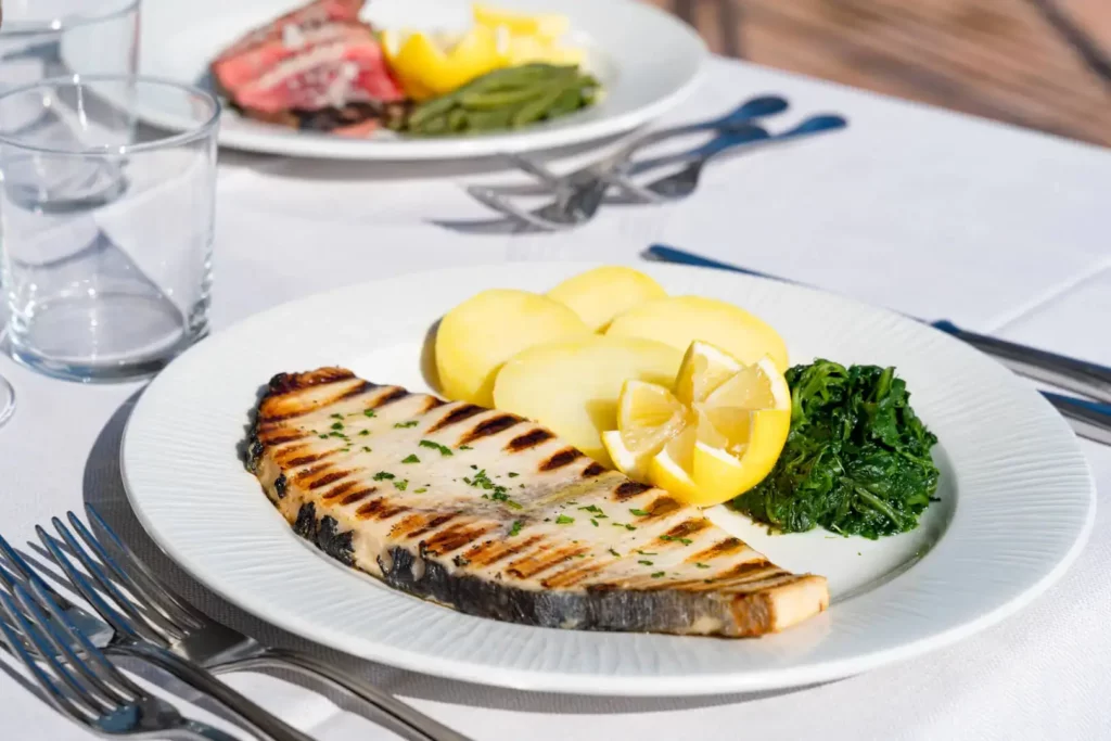 Piatti di pesce e carne con contorni.